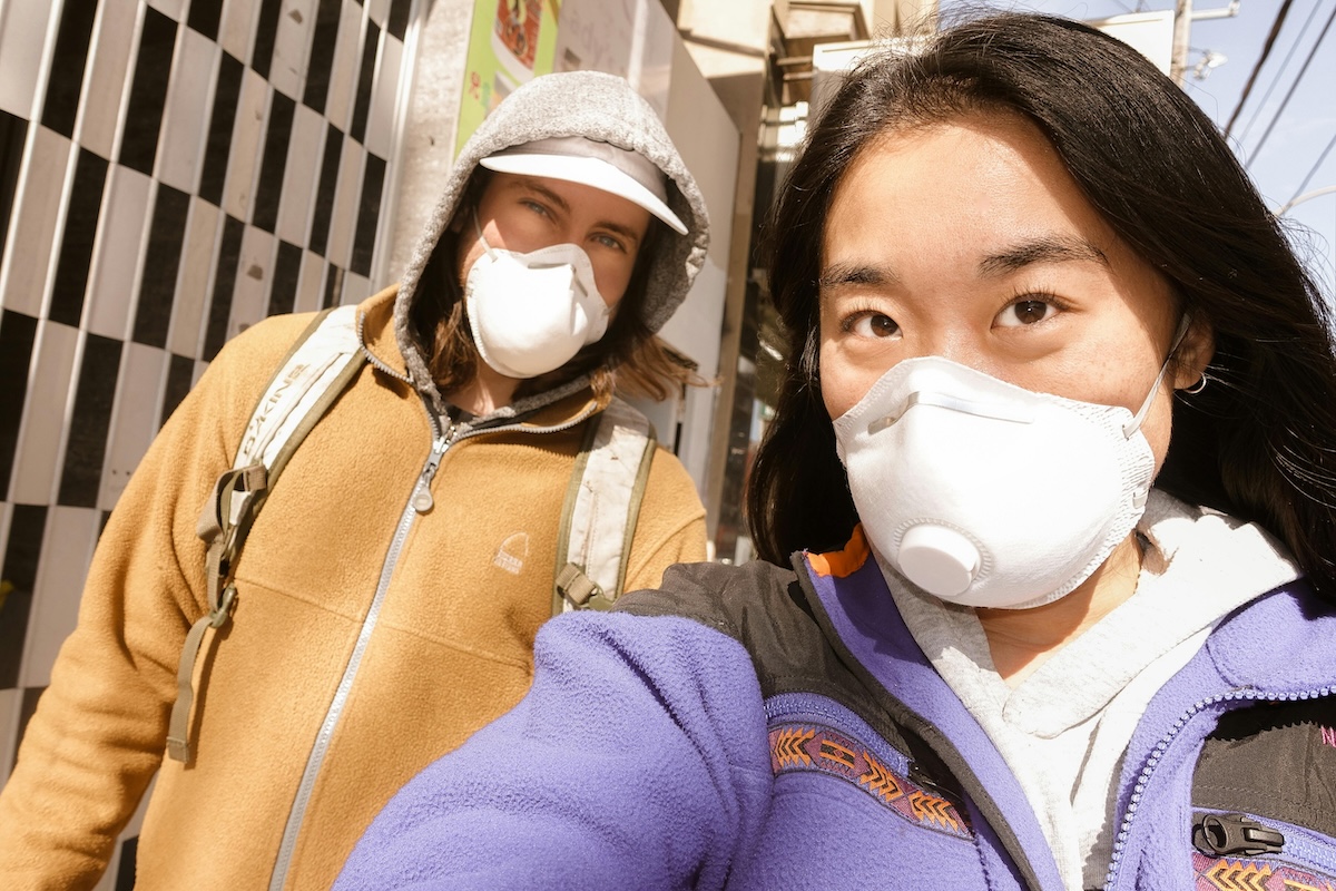Two women wearing N95 or equivalent masks. Both look happy.